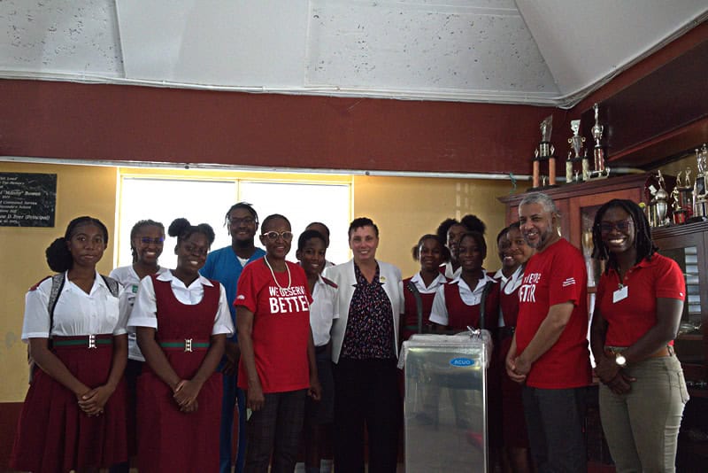 The Muslim Students Association of the Ross University School of Medicine's water cooler was delivered by the Chair of the National NCD Commission Sulieman Bulbuia to Principal of the Graydon Sealy Secondary School June Shyrelle Howard-Gittens. Looking on is Programme Manager of the Childhood Obesity Prevention Coalition Francine Charles, Youth Advocacy Officer Michron Robinson, and other youth advocates and students